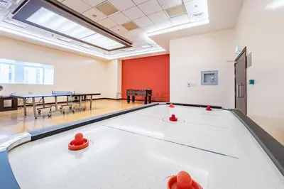 a ping pong table in a room with tables and chairs at Revamped 1BR Unit with Partial Sea & Palm Jumeirah Views Close to Beach , Elite Residence, Dubai Marina by Deluxe Holiday Homes in Dubai