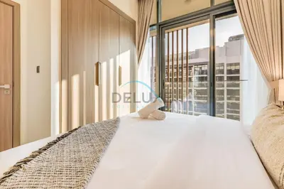 a bedroom with a bed and a large window at Pool Views 1BR Close to Major Landmarks in Azizi Riviera 18, Al Merkadh by Deluxe Holiday Homes in Dubai