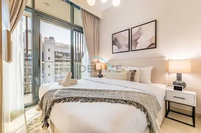 a bedroom with a bed and a large window at Pool Views 1BR Close to Major Landmarks in Azizi Riviera 18, Al Merkadh by Deluxe Holiday Homes in Dubai