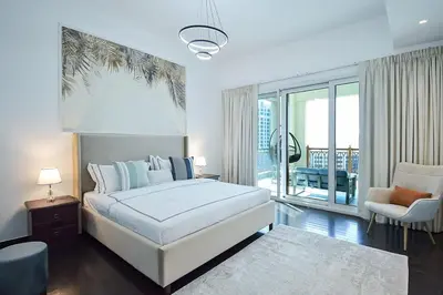 a bedroom with a white bed and a large window at Exclusive 2BR Home Marina Residence 4, The Palm in Dubai