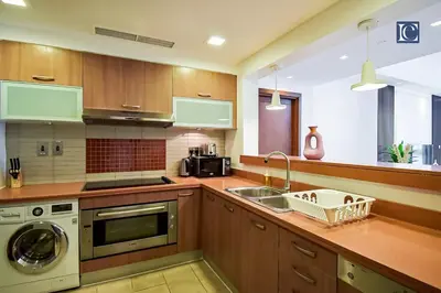 a kitchen with a sink and a washing machine at Exclusive 2BR Home Marina Residence 4, The Palm in Dubai