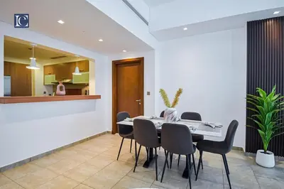 a dining room with a table and chairs at Exclusive 2BR Home Marina Residence 4, The Palm in Dubai