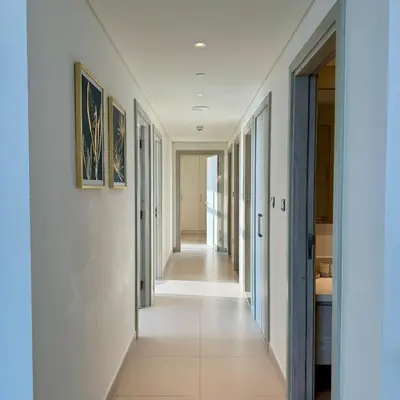 a corridor in a house with white walls and a long hallway at THE COVE Creek Harbour in Dubai