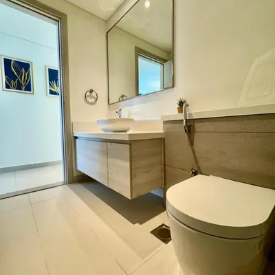 a bathroom with a toilet and a sink and a mirror at THE COVE Creek Harbour in Dubai