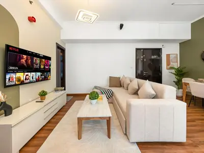 a living room with a white couch and a tv at Spacious High Floor Apartment Dubai Marina in Dubai