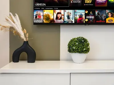 a white cabinet with a tv and a plant on it at Spacious High Floor Apartment Dubai Marina in Dubai