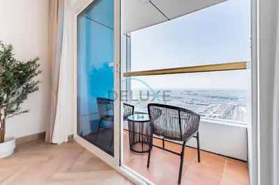 a room with a table and chairs on a balcony at Upgraded 1BR Overlooking Palm Jumeirah & Sea Views from Living to Bedroom, Elite Residence, Dubai Marina by Deluxe Holiday Homes in Dubai
