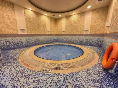 a large swimming pool in a building with a tile floor at Upgraded 1BR Overlooking Palm Jumeirah & Sea Views from Living to Bedroom, Elite Residence, Dubai Marina by Deluxe Holiday Homes in Dubai
