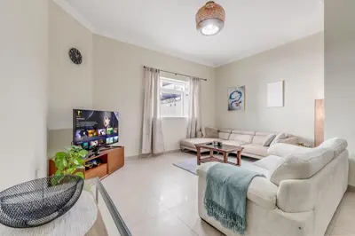 a living room with a couch and a tv at Waves - Spacious 1BR with Balcony & Cozy Interiors in JVC in Dubai