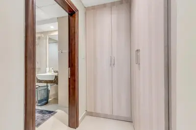a bathroom with white cabinets and a mirror at Waves - Spacious 1BR with Balcony & Cozy Interiors in JVC in Dubai