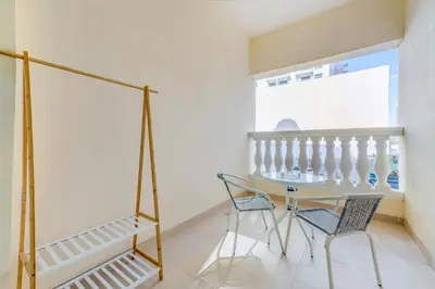 a dining room with a glass table and two chairs at Waves - Spacious 1BR with Balcony & Cozy Interiors in JVC in Dubai