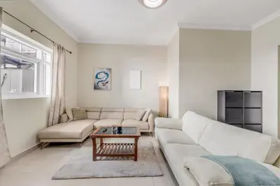 a living room with a couch and a table at Waves - Spacious 1BR with Balcony & Cozy Interiors in JVC in Dubai