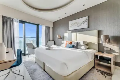 a hotel room with a large bed and a desk at GuestReady - Luxurious interiors in Business Bay in Dubai