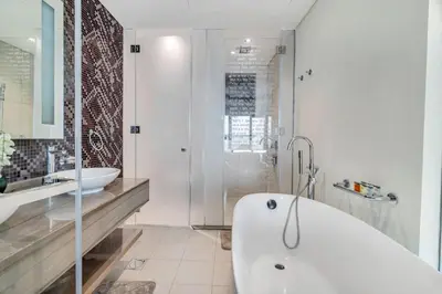 a white bathroom with a tub and a sink at GuestReady - Luxurious interiors in Business Bay in Dubai