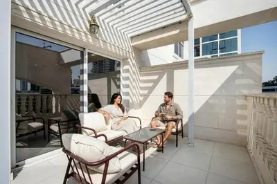 a man and a woman sitting on a patio at Livbnb-Modern 1BR Oasis with Stunning Terrace, JVC in Dubai