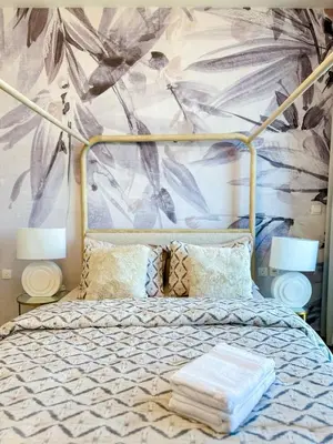 a bedroom with a bed with a floral wallpaper at Luxury Meets Serenity 2BR Apt in Noura Tower in Dubai