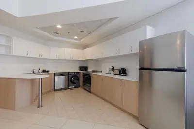 a large kitchen with a stainless steel refrigerator at Waterfront flat Stunning view Sleeps 6 in Dubai