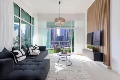 a living room with a couch and a tv at Waterfront flat Stunning view Sleeps 6 in Dubai
