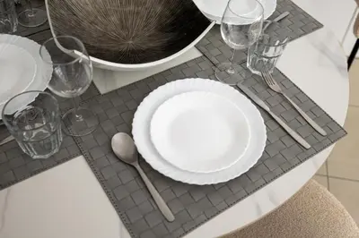 a table with white plates and glasses on a table at 1BR Botanica Dubai Marina in Dubai