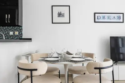 a dining room with a white table and chairs at 1BR Botanica Dubai Marina in Dubai