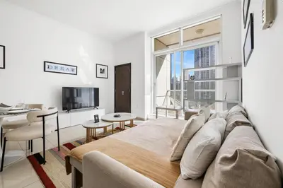 a bedroom with a large bed and a living room at 1BR Botanica Dubai Marina in Dubai