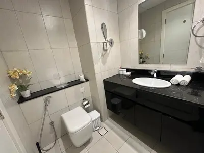 a bathroom with a toilet and a sink and a mirror at Stunning Studio at JVC Damac Ghalia - Msgetaways in Dubai