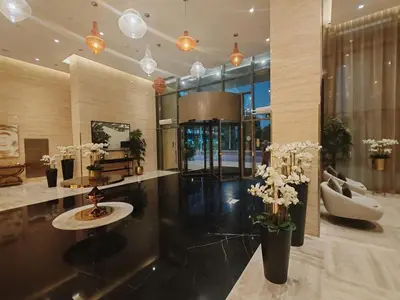 a lobby with vases of flowers in a building at Stunning Studio at JVC Damac Ghalia - Msgetaways in Dubai