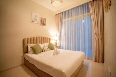 a bedroom with a large white bed with a window at Cozy Retreat with Burj Views by Bnbeyond in Dubai