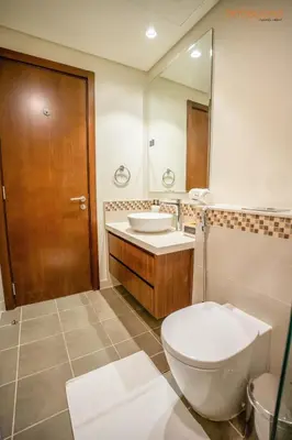 a bathroom with a toilet and a sink and a mirror at Cozy Retreat with Burj Views by Bnbeyond in Dubai