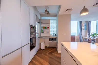 a kitchen with white cabinets and a counter top at 160M2 Modern 2-bedrooms apartment with fantastic views in Dubai