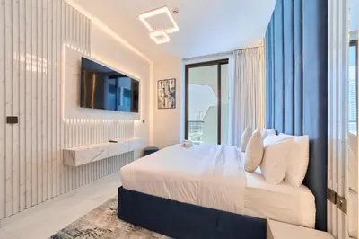 a bedroom with a large bed and a tv at FAM Living - Samana Park Views - Brandnew 1Bed in Dubai