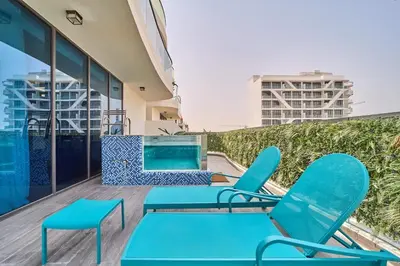 a balcony with blue chairs and a swimming pool at FAM Living - Samana Park Views - Brandnew 1Bed in Dubai