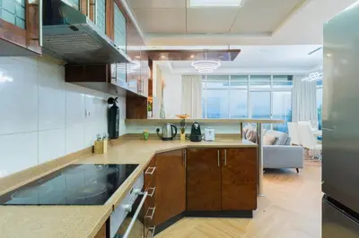 a kitchen with a counter and a living room at New Elegant & Luxury 3BR Apartment In Dubai Marina in Dubai