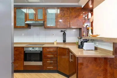 a kitchen with wooden cabinets and a counter top at New Elegant & Luxury 3BR Apartment In Dubai Marina in Dubai
