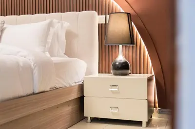 a lamp on a night stand next to a bed at New Elegant & Luxury 3BR Apartment In Dubai Marina in Dubai