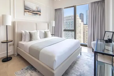 a bedroom with a large bed and a large window at Frank Porter - Grande Signature Residences in Dubai