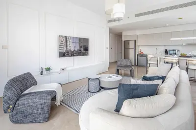 a living room with two couches and a kitchen at Frank Porter - Grande Signature Residences in Dubai