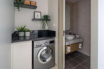 a bathroom with a washing machine and a sink at Frank Porter - Aykon City Tower C in Dubai