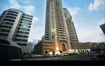 two tall buildings with cars parked in a city at Destination Partition Room in Tecom Near Metro in Dubai