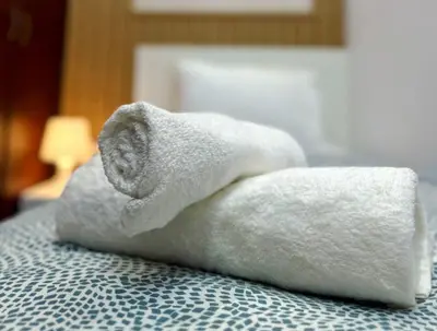 a white towel sitting on top of a bed at Destination Partition Room in Tecom Near Metro in Dubai