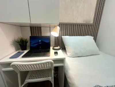 a desk with a laptop computer on top of a bed at Elegance Partition Room in Tecom Near ICM Metro in Dubai