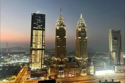 a group of tall buildings in a city at night at Beautiful Partition Room in Barsha heights in Dubai