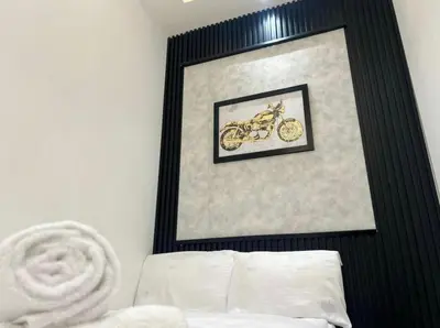 a picture of a motorcycle in a frame above a bed at Attraction Partition Room in Barsha heights Tecom in Dubai