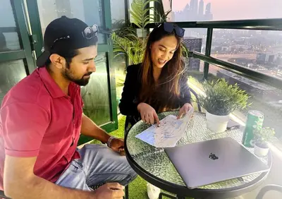 a man and a woman sitting at a table with a laptop at Attraction Partition Room in Barsha heights Tecom in Dubai