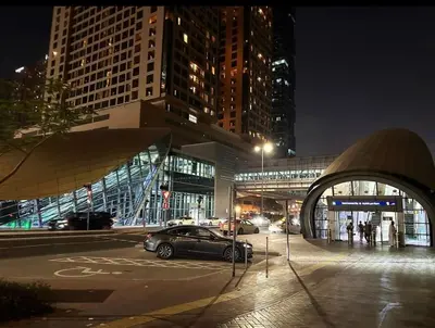 a car parked in a parking lot in a city at night at Network Partition Room Near Internet City Metro in Dubai