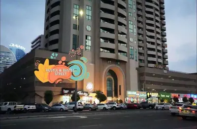 a large building with cars parked in a parking lot at Network Partition Room Near Internet City Metro in Dubai