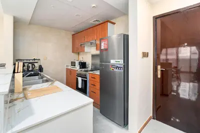a kitchen with a stainless steel refrigerator and wooden cabinets at Perfect Marina Stay - Ideal for great Holidays in Dubai
