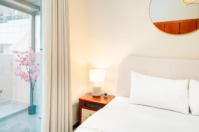 a bedroom with a bed and a vase of flowers on a table at Perfect Marina Stay - Ideal for great Holidays in Dubai