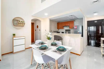 a kitchen and dining room with a white table and chairs at Perfect Marina Stay - Ideal for great Holidays in Dubai