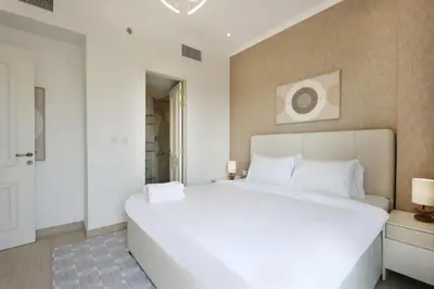 a bedroom with a large white bed in a room at Livbnb - Homey 1B with Spacious Terrace in District 14, JVC in Dubai